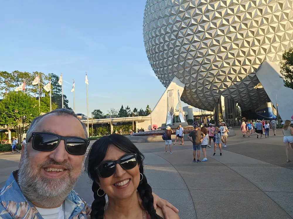 Sami and Kruti Quazi smiling in front of Spaceship Earth at Epcot
